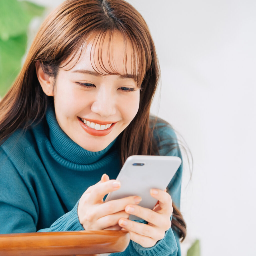 スマフォで予約をしている女性