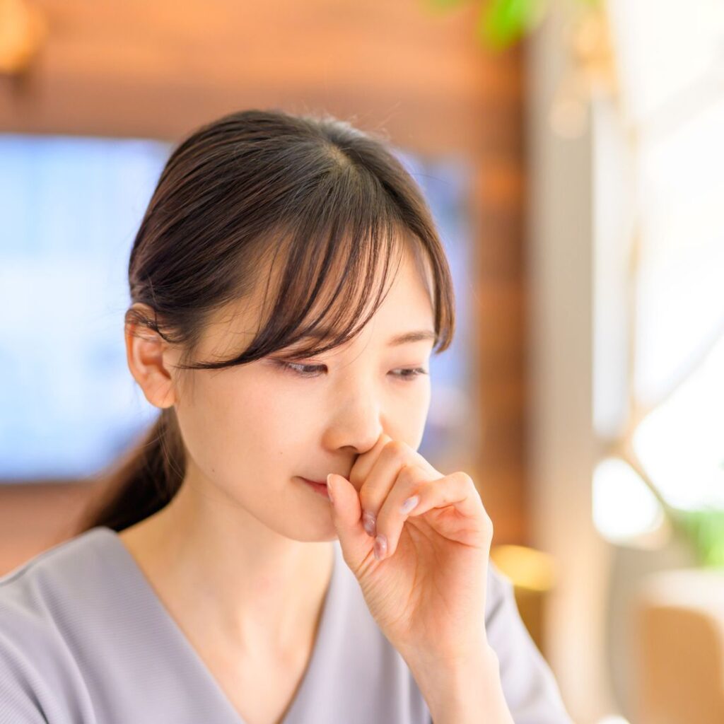 鼻をこする女性